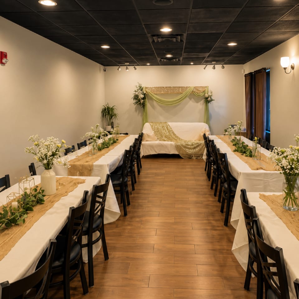 Engagement event setup with floral table decorations and a green and gold backdrop at Kabob Cafe & Grill.